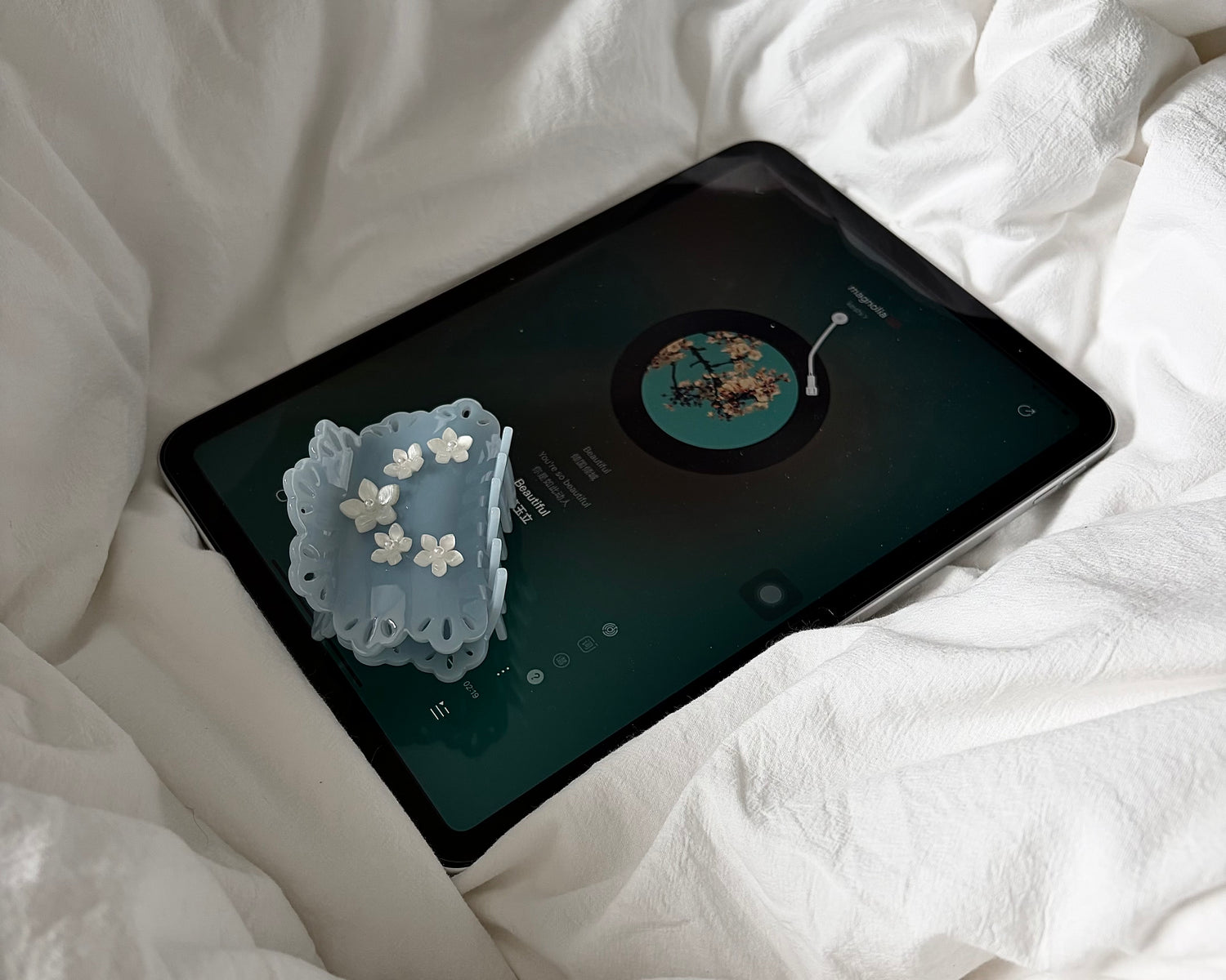 blue scalloped lace cutout claw clip on an IPad resting in bed