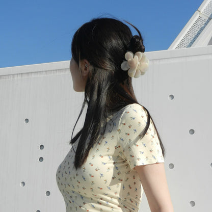 girl-in-yellow-pink-blossom-hair-claw-clip-halfup-hairstyle