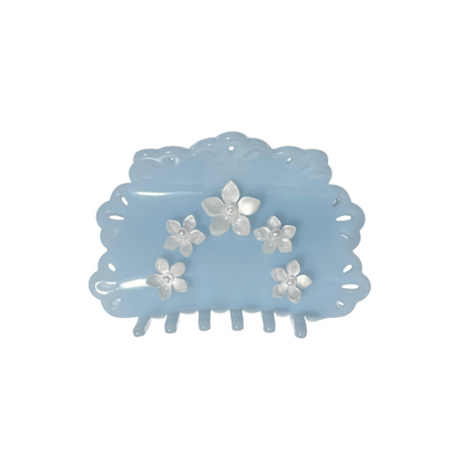 Blue hair claw clip with floral designs on a white background