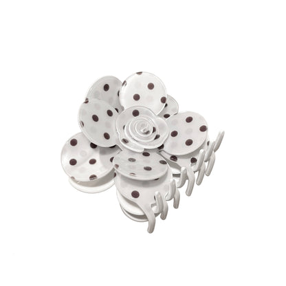 White flower hair claw clip with polka dot design on a white background