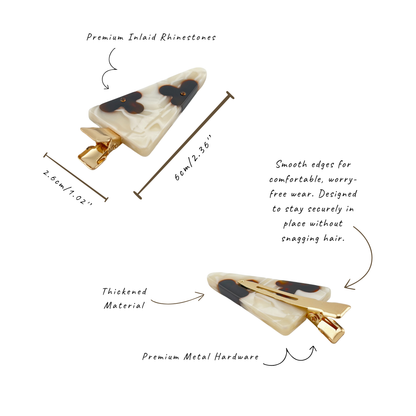 Two views of a triangular hair claw clip with text callouts and measurement arrows on a white background. The clip has a cream/off-white translucent base with dark brown or black inlay details and gold-tone metal hardware.